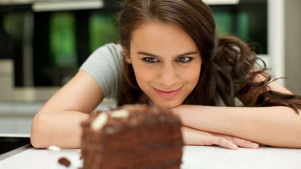 کیک کو لالچ کے نظر سے دیکھتی ایک خاتون