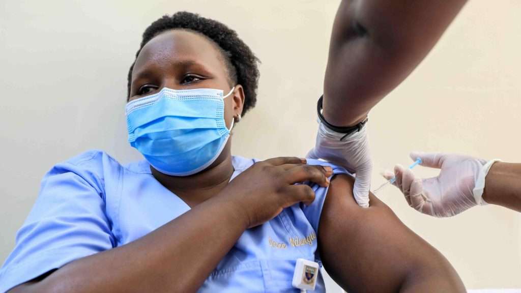 Kenya starts administering AstraZeneca vaccines to health workers - a Kenyan healthcare worker gets vaccinated with an Oxford/AstraZeneca COVID-19 vaccine dose during the official launch of vaccinating health workers at the Kenyatta National Hospital (KNH) in Nairobi, Kenya, on 5 March 2021