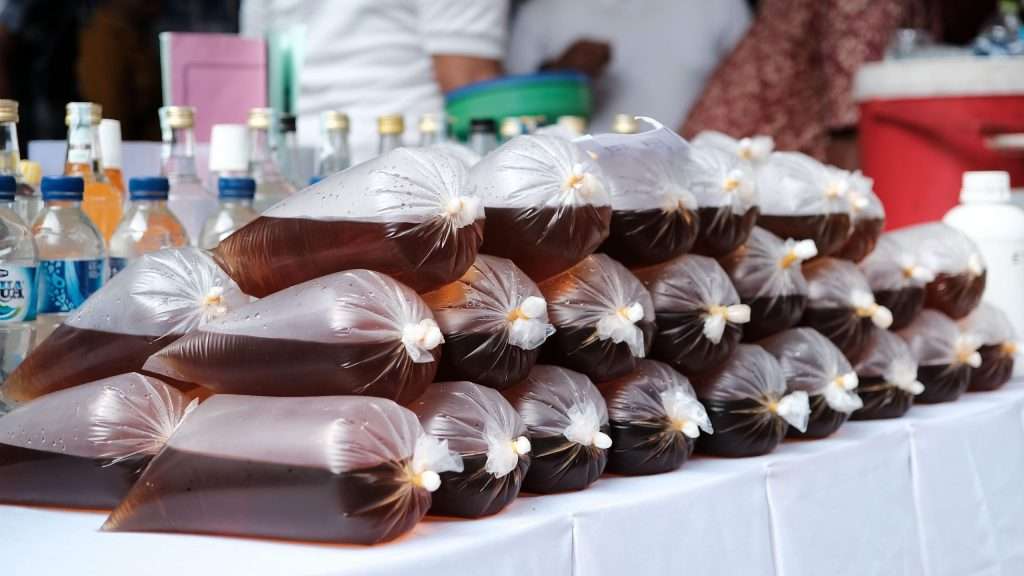 Bags of confiscated illicit red drink displayed on a table in Jakarta